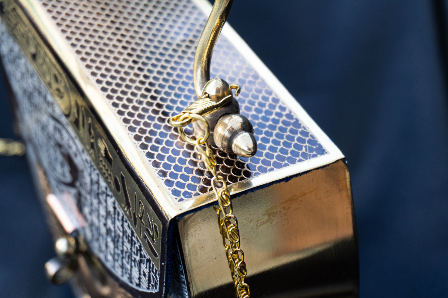 Salma - Handmade Bag, close-up top view of handle and handmade art with chain and handle 